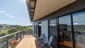 A balcony with a wooden floor, two chairs, and a table. - Sunset Meadows in Sunset Strip (Sunset Strip)