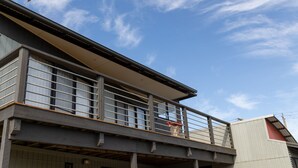 A two-story building with a balcony and large windows. - Sunset Meadows in Sunset Strip (Sunset Strip)