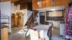 A cozy interior with a dining area, kitchen, and staircase. - Cozy 3-room apt, 7 pers, near cable car (Châtel)