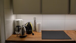 Une cuisine équipée d’une bouilloire, d’une machine à café et d’un tapis noir sur le plan de travail.