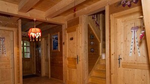 A wooden interior with a tiled floor, a staircase, and a door with a heart-shaped decoration. - 8-room chalet, 16 pers, near village, parking, WiFi, pets allowed (Châtel)