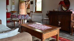 Un salon chaleureux avec une table en bois, un canapé et un coin repas avec des chaises.