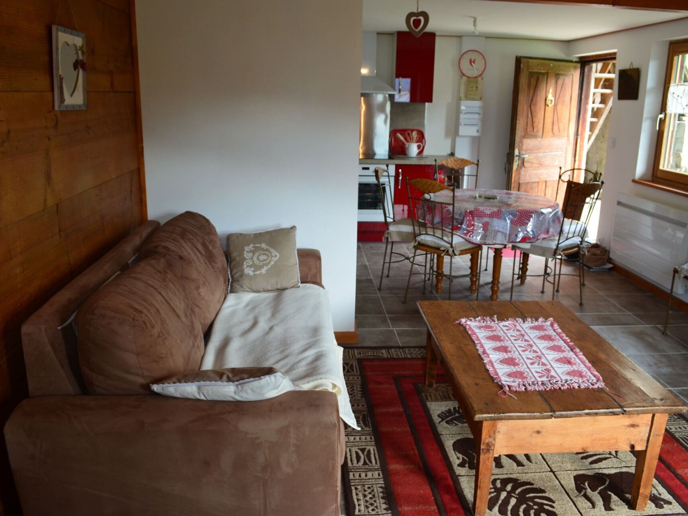 A cozy living room with a brown sofa, a wooden coffee table, and a patterned rug.