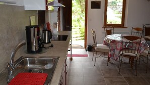 La cuisine est équipée d’un évier, d’une machine à café et d’une bouilloire. Un coin repas avec une table et des chaises est également à disposition.