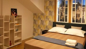 Une chambre à coucher avec un lit, un luminaire au plafond, une fenêtre donnant sur un beau paysage et une bibliothèque.