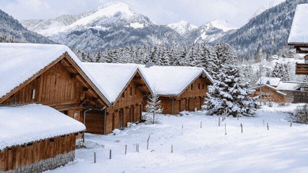 Wooden cabins with snow-covered roofs, surrounded by snow-covered trees and mountains in the background. - Charming 2-BR Apt for 6 with Balcony, Near Super-Châtel Lift (Châtel)