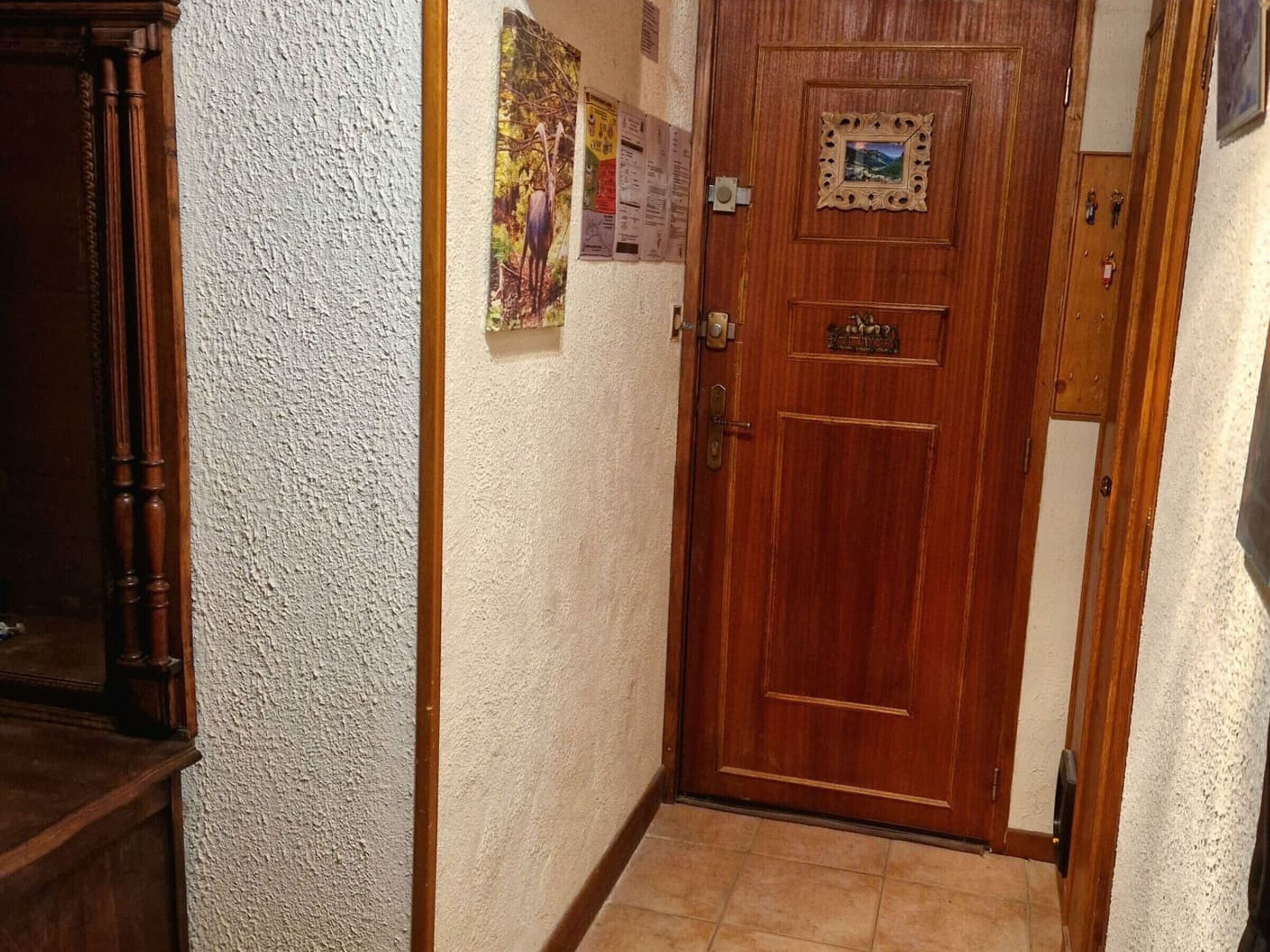 Una puerta de madera con manija de bronce, una pequeña placa y una cerradura.