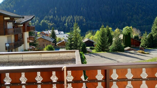 A mountain village with traditional wooden buildings, a clear view of the surrounding forest, and a paved area in the foreground. - Studio Cozy in Châtel with Mountain View, Balcony, and Parking (Châtel)