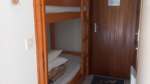 A bunk bed room with a wooden door and a doormat. - Studio Cozy in Châtel with Mountain View, Balcony, and Parking (Châtel)