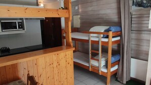 A compact room with bunk beds, a kitchenette, and a small dining area. - Studio 4 Pers, Near Chairlift, South Balcony (Châtel)