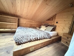 A wooden cabin bedroom with a single bed, a nightstand, and a built-in bench. - 4-Room Chalet, 8 People, Wifi, Parking, Châtel (Châtel)