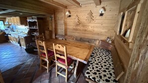 Un interior de madera con una mesa de comedor, sillas y un banco.