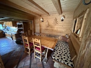 A wooden interior with a dining table, chairs, and a bench. - 4-Room Chalet, 8 People, Wifi, Parking, Châtel (Châtel)