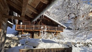 Una cabaña de madera con balcón que da a un paisaje nevado.