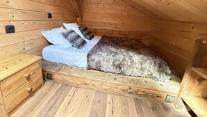 A small, wooden, attic-style bedroom with a single bed, a nightstand, and a drawer unit. - 4-Room Chalet, 8 People, Wifi, Parking, Châtel (Châtel)