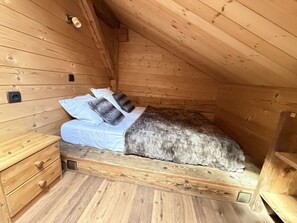 A small, wooden, attic-style bedroom with a single bed, a nightstand, and a drawer unit. - 4-Room Chalet, 8 People, Wifi, Parking, Châtel (Châtel)
