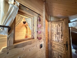 A wooden cabin interior with a window, a door, and a curtain. - 4-Room Chalet, 8 People, Wifi, Parking, Châtel (Châtel)