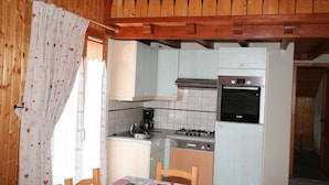A compact kitchen with a Bosch oven, a gas stove, and a sink. There is a dining table with a checkered tablecloth. - 3-room apartment for 7 in Châtel, near center and lifts, with balcony and parking (Châtel)