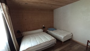 A small, cozy room with two single beds, wooden walls, a ceiling with recessed lighting, and a window with curtains. - Apartment for 5 near cable car, pets allowed (Châtel)