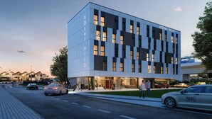 A modern hotel with a glass facade, multiple floors, and a flat roof.