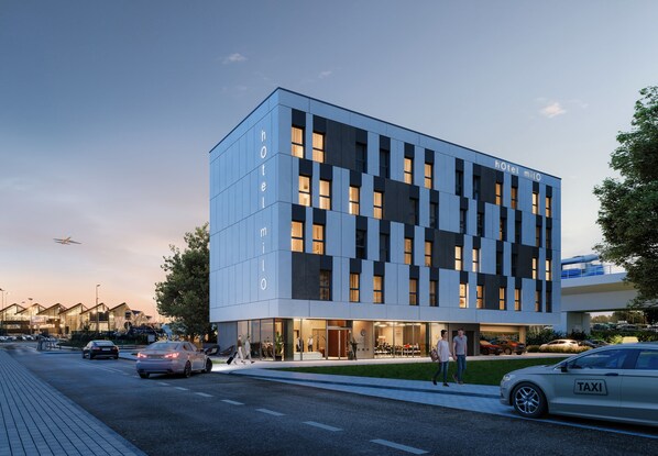 Un hôtel moderne doté d’une façade en verre, de plusieurs étages et d’un toit plat.