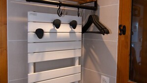 Een badkamer met een handdoekrek, een houten plank en een deur.