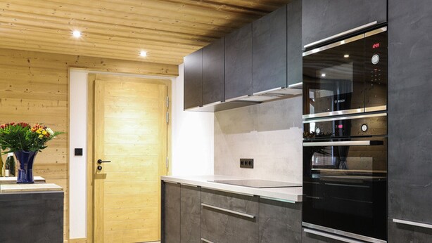 A modern kitchen with dark cabinets, stainless steel appliances, and a wooden ceiling. - Large 7-room chalet, 15 people, sauna, jacuzzi in Châtel (Châtel)