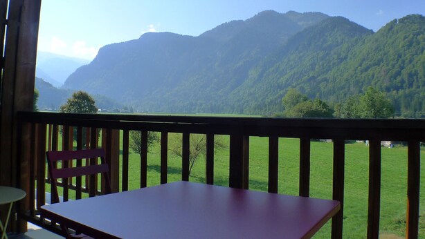 A wooden deck with a table and chair, overlooking a mountainous landscape. - Calm Duplex T4 with parking, pets allowed in Samoëns (Samoëns)