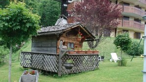 A small wooden structure with a sloped roof, a wooden deck, and potted plants. - Apartment Châtel - 5 People, Near Slopes, Pets Allowed (Châtel)