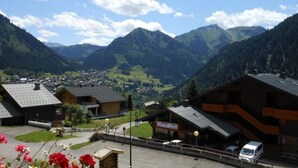 A mountain village with traditional buildings, a parking area, and a view of the surrounding mountains. - Apartment Châtel - 5 People, Near Slopes, Pets Allowed (Châtel)