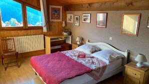 A cozy room with a bed, a desk, a chair, and a window with a view. - Apartment Châtel - 5 People, Near Slopes, Pets Allowed (Châtel)