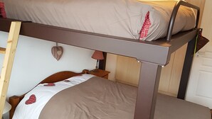 A bunk bed with a headboard, a bedside table with a lamp, and a heart-shaped decoration on the wall. - Châtel Apartment 2 rooms, 5 ppl, South Balcony, Parking (Châtel)