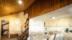 Un intérieur en bois comprenant un coin repas, une cuisine et un escalier.