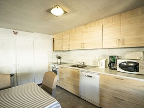 A compact kitchen with wooden cabinets, a stainless steel sink, a microwave, a coffee maker, and a dishwasher. - 3-Room Apartment in Châtel, Sleeps 7, Near Ski Lifts, Balcony (Châtel)