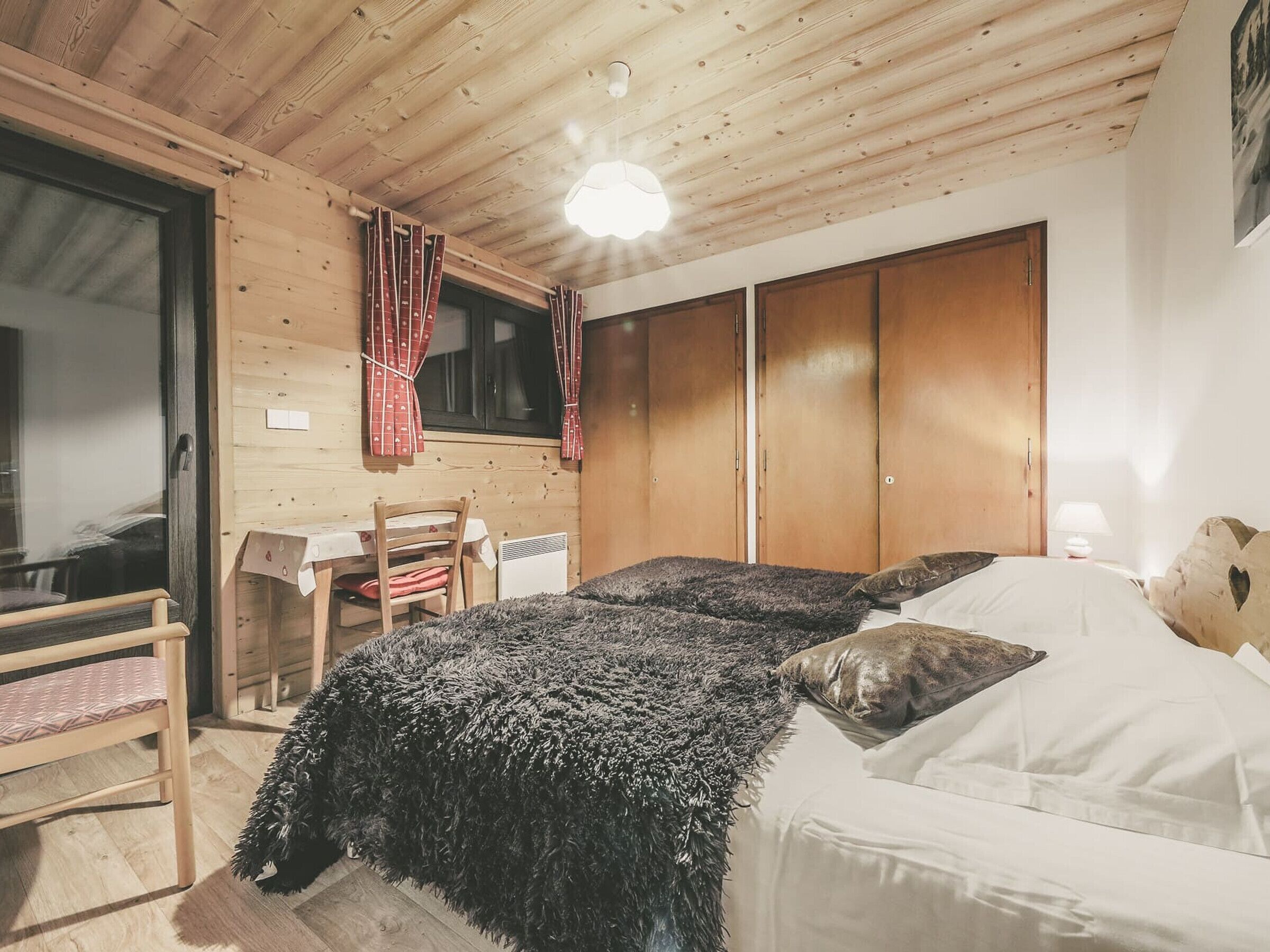 Ein gemütliches Zimmer mit einem Bett, einem Schreibtisch und einem Stuhl.