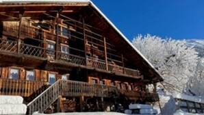 Eine Holzhütte mit Balkon, umgeben von Schnee.