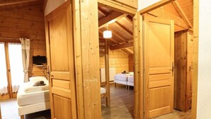 Una cabaña de madera con un interior acogedor, que incluye una cama, una mesita y un banco.