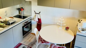A compact kitchen with a white table, a coffee machine, and a small decorative tree. - Châtel Apartment 4 ppl, balcony, parking, pets allowed (Châtel)