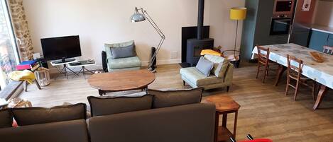A cozy living room with a sofa, a coffee table, a TV, and a fireplace.