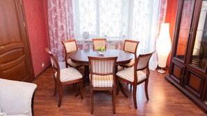 A dining area with a round table, six chairs, and a vase of flowers. - Comfortable apartment (Minsk)
