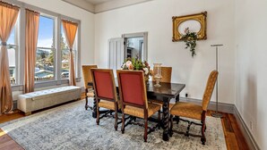Un comedor con una mesa de madera, seis sillas, un banco y un espejo grande en la pared.
