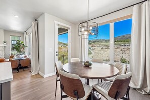 Un espace repas avec une table ronde, des chaises et une vue sur un paysage désertique.