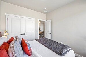 A bedroom with a bed, pillows, a bedside table, and a nightstand. - Deer Springs 4BR | Private Hot Tub | Deer Valley & Jordanelle Views (Hideout)