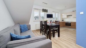 A modern apartment with a dining area, kitchen, and living room. - Cozy Studio in Quiet Neighborhood | Balcony, Parking (Wrocław)