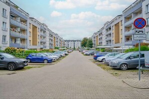 A residential street with parked cars and apartment buildings. - Cozy Studio in Quiet Neighborhood | Balcony, Parking (Wrocław)