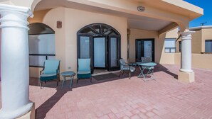 A covered outdoor seating area with chairs and a table, a door with glass panels, and a clear blue sky. - Casa Serena 3 Bed 2 Bath By FMI Rentals (Puerto Peñasco)
