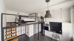 Ein modernes Loft-Zimmer mit Schlafgalerie, Küchenzeile und Esstisch.