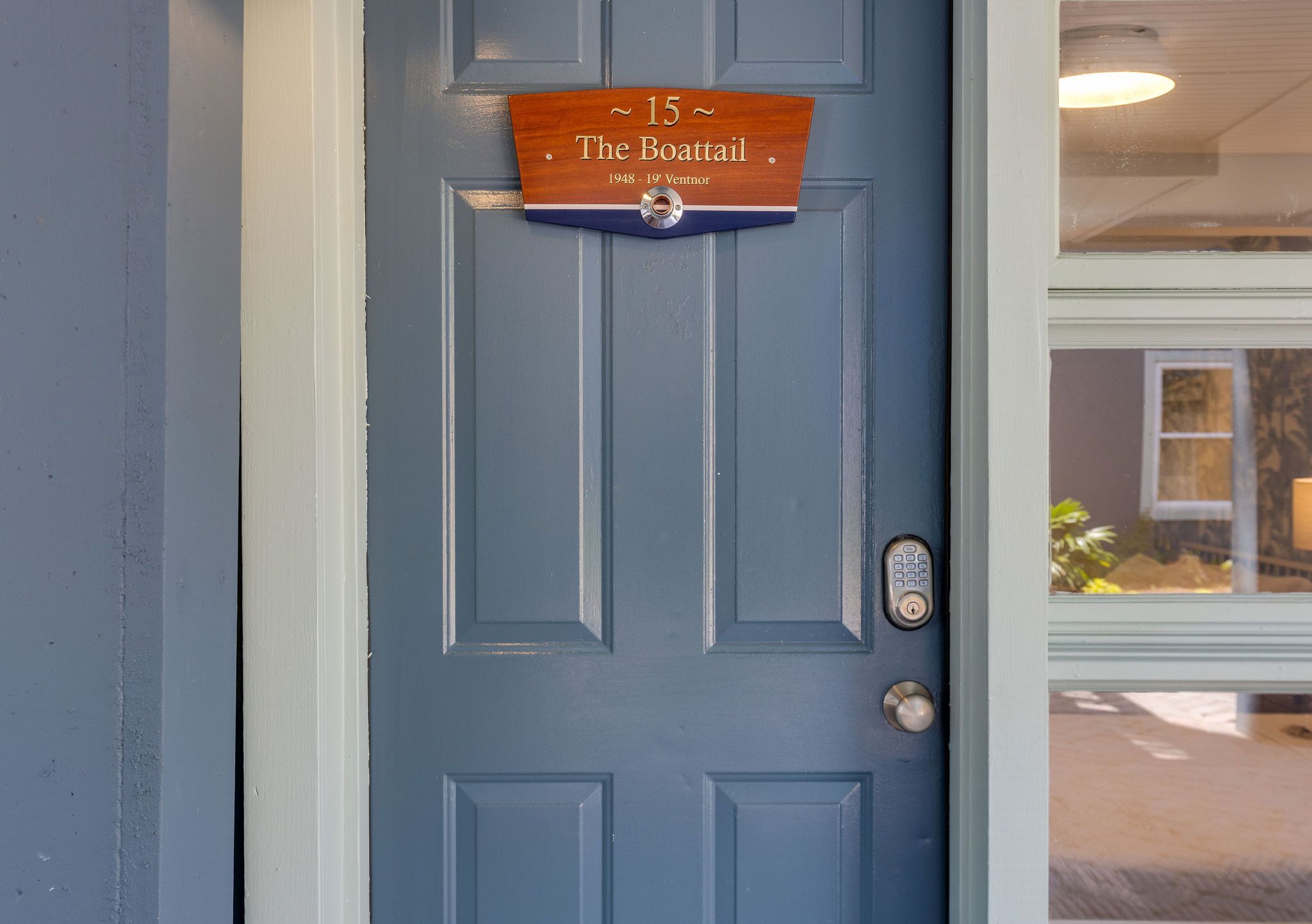 A blue door with a wooden plaque reading "15 The Boattail 1948-19 Ventnor."