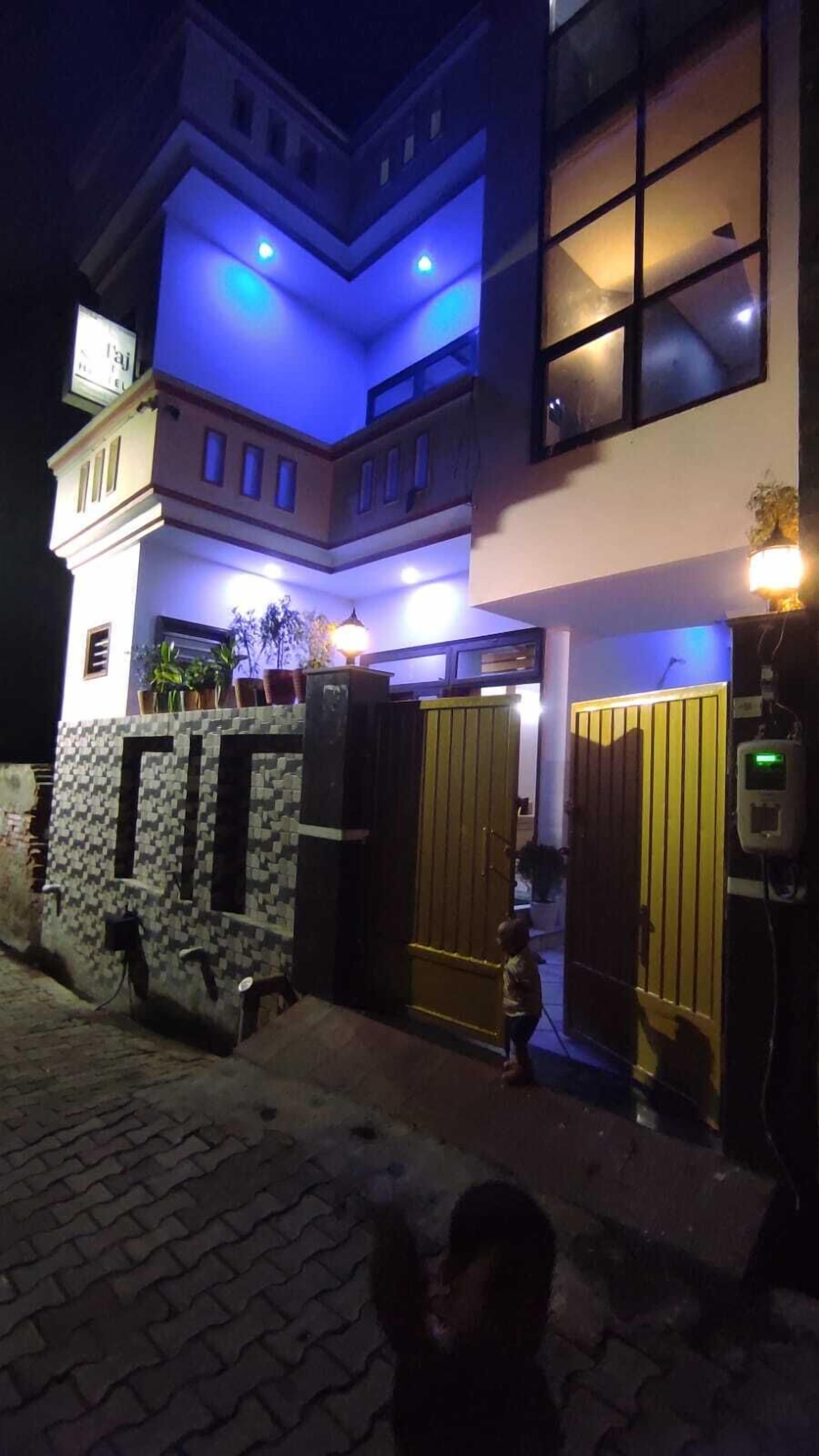 Un edificio de dos pisos con diseño moderno, que cuenta con un balcón y un acceso con portón.