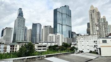 A city skyline with modern high-rise buildings, including a distinctive curved skyscraper and a tall, rectangular building with reflective glass.